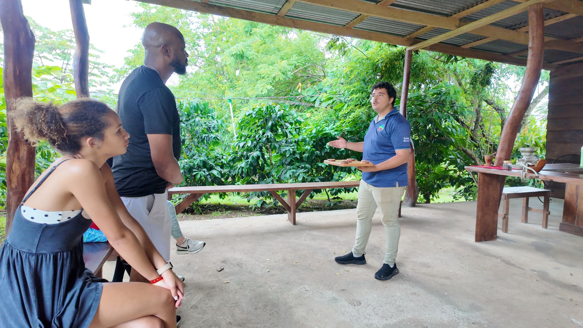 Guide explaining cacao and coffee to guests near Bijagua