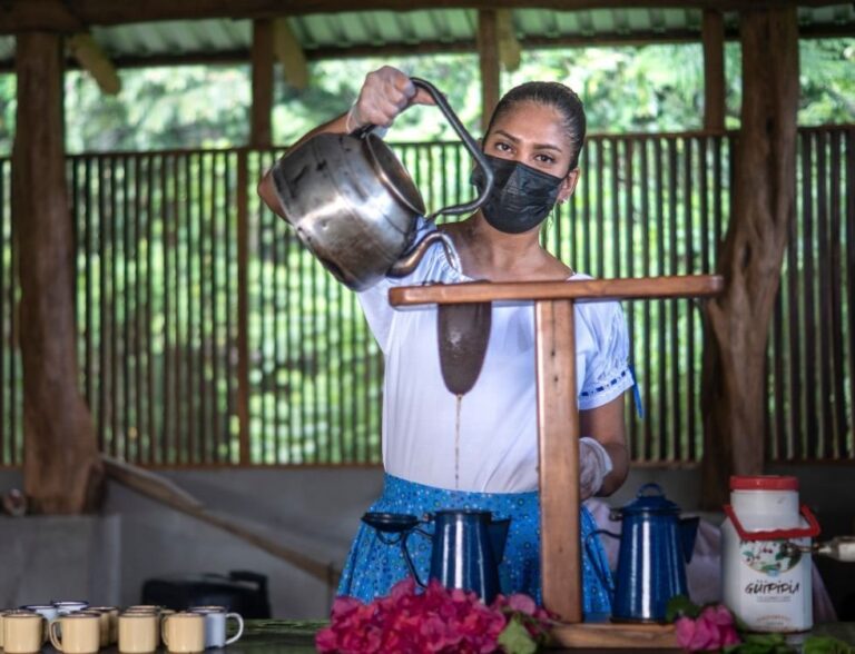 Host in a traditional dress brewing Costa Rican coffee with a cloth chorreador on a cultural tour, Guanacaste