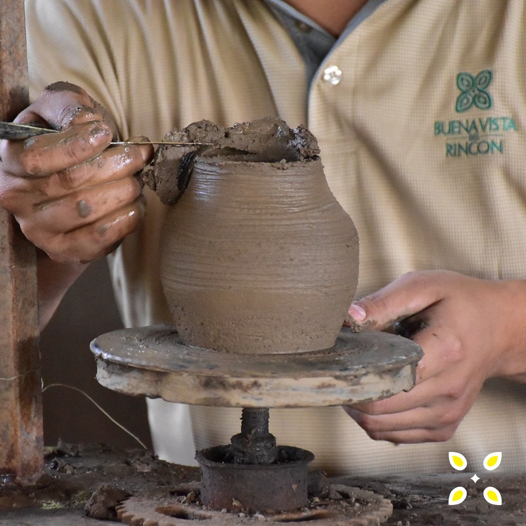 Potter shaping a clay pot on a traditional wheel
