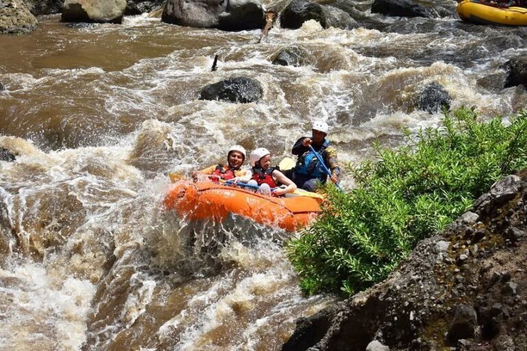 Orange raft with guests and guide running a rapid on the Tenorio River, Guanacaste, Costa Rica