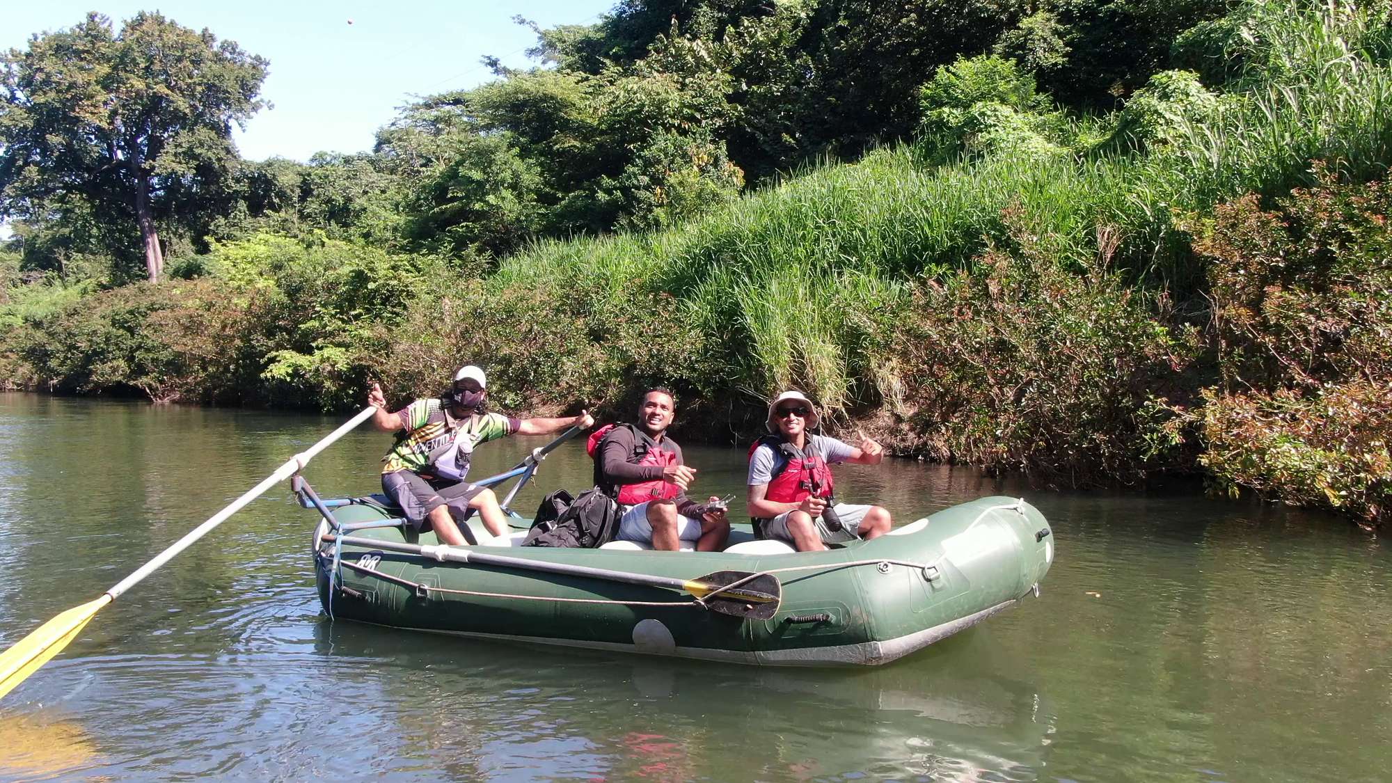 Guests and their guide smiling in a raft on a safari float in Guanacaste