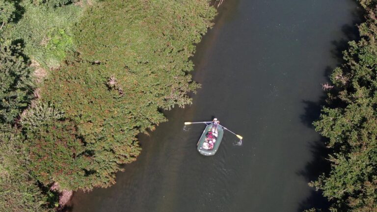 Aerial view of a raft floating down a calm, forest-lined river on a safari float in Guanacaste, Costa Rica