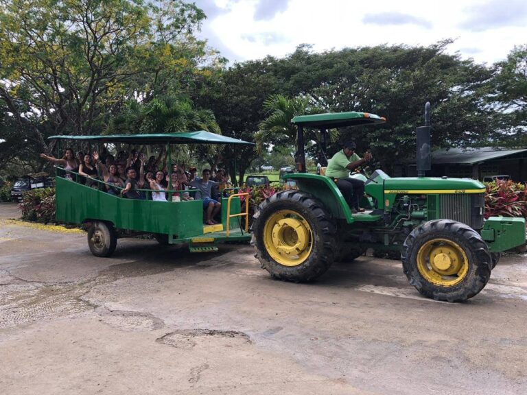 Guests waving from a tractor-pulled wagon on the way to the hot springs at Rincón de la Vieja, Costa Rica