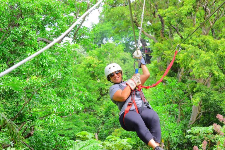Smiling guest in a helmet and harness on a zip line at Rincón de la Vieja, Guanacaste, Costa Rica