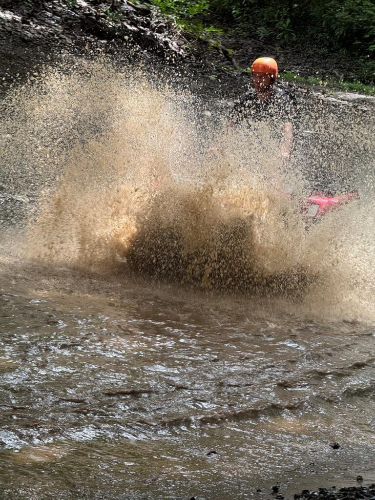 ATV throwing a big splash of water during a river crossing