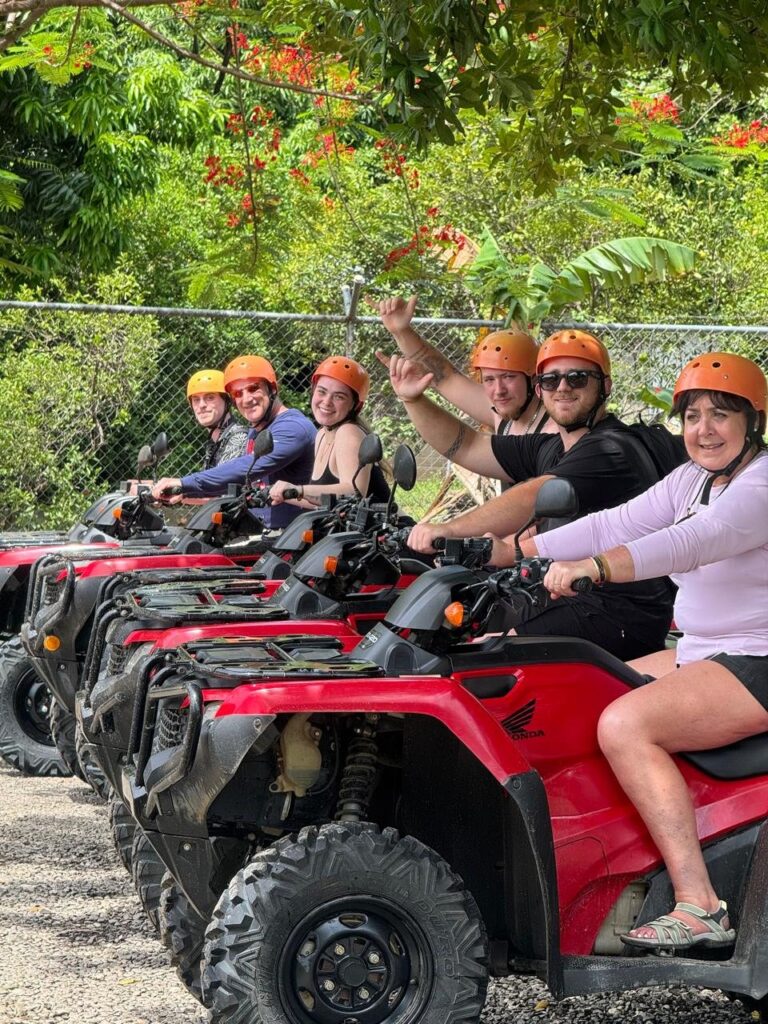 Group of guests in helmets lined up on red ATVs before the tour