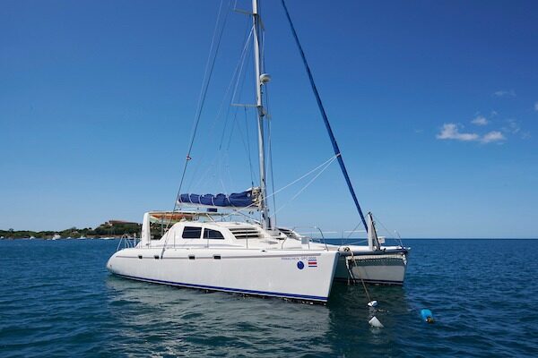 White sailing catamaran anchored in a calm blue bay near Flamingo, Guanacaste, Costa Rica