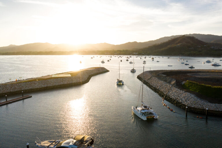 Aerial view of two catamarans heading out of Flamingo Marina into the bay at sunset, Guanacaste, Costa Rica