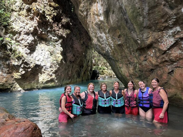 Group of women in life jackets standing in the Río Blanco canyon on the La Leona hike