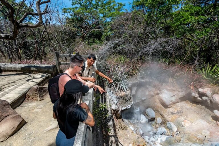 Naturalist guide showing two guests a steaming fumarole on the Las Pailas trail, Rincón de la Vieja, Costa Rica