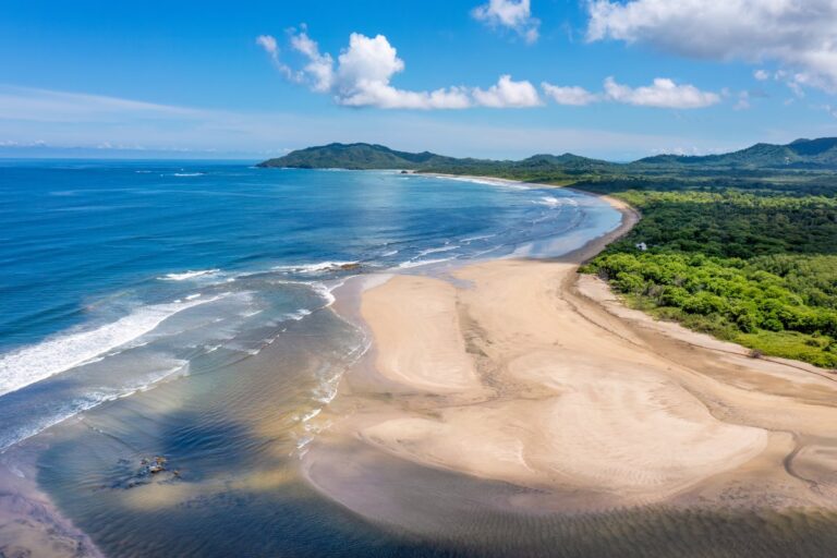 Aerial view of the bay and sandbars at the Tamarindo estuary under a blue sky