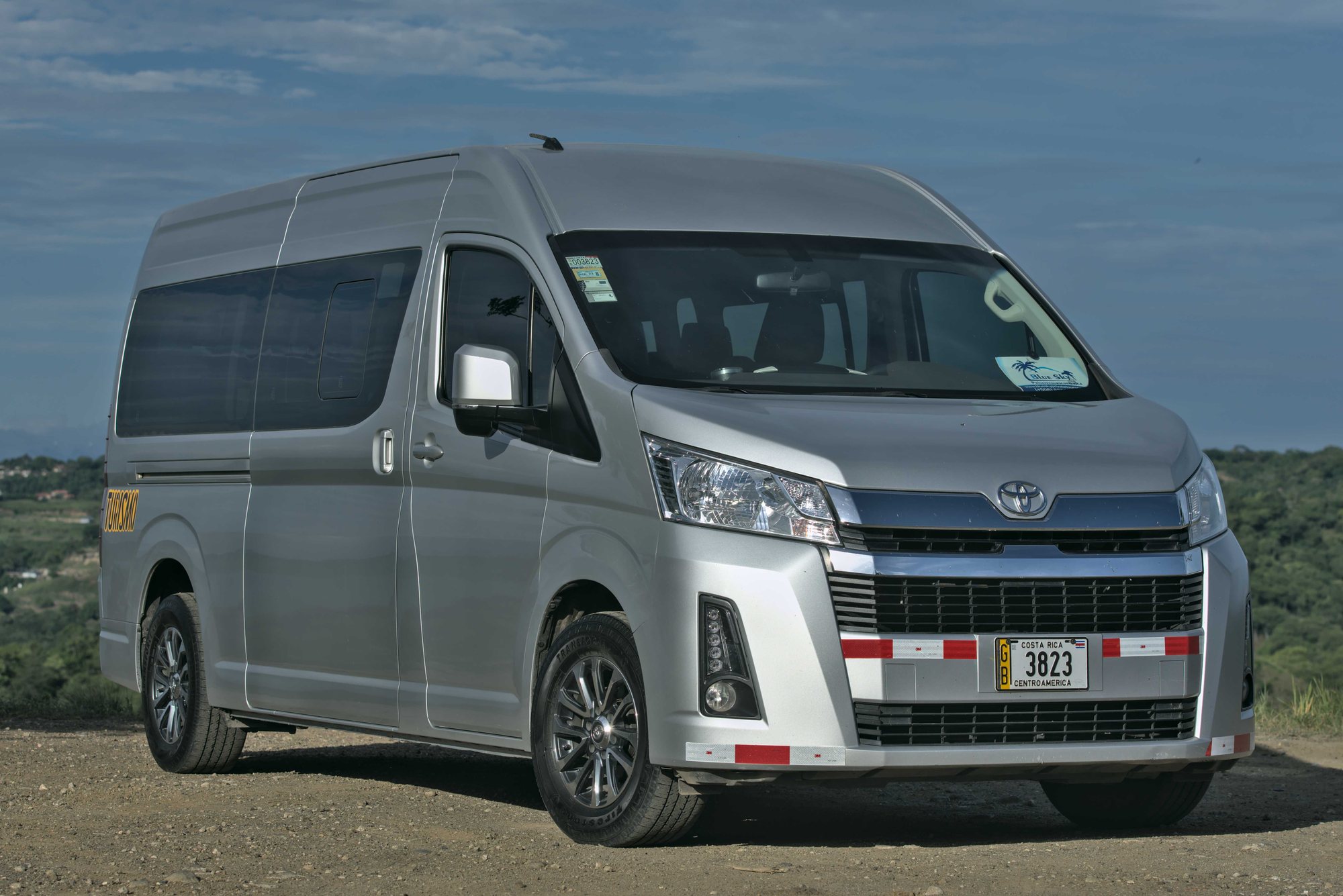 Side view of a silver Toyota Hiace high-roof van for private shuttles in Costa Rica