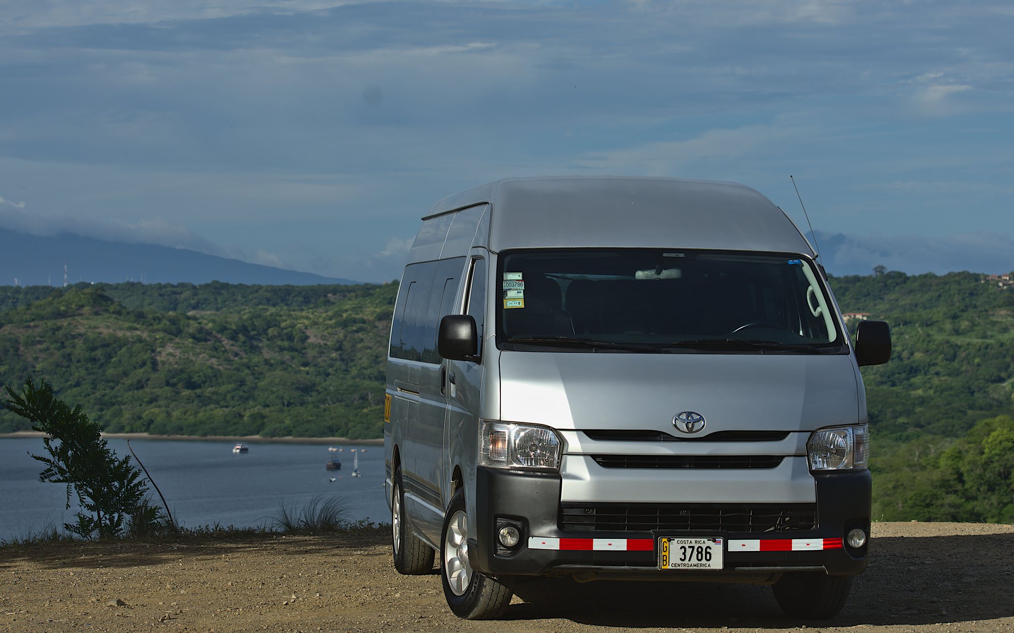 Silver Toyota Hiace private tour van parked above a bay in Guanacaste, Costa Rica